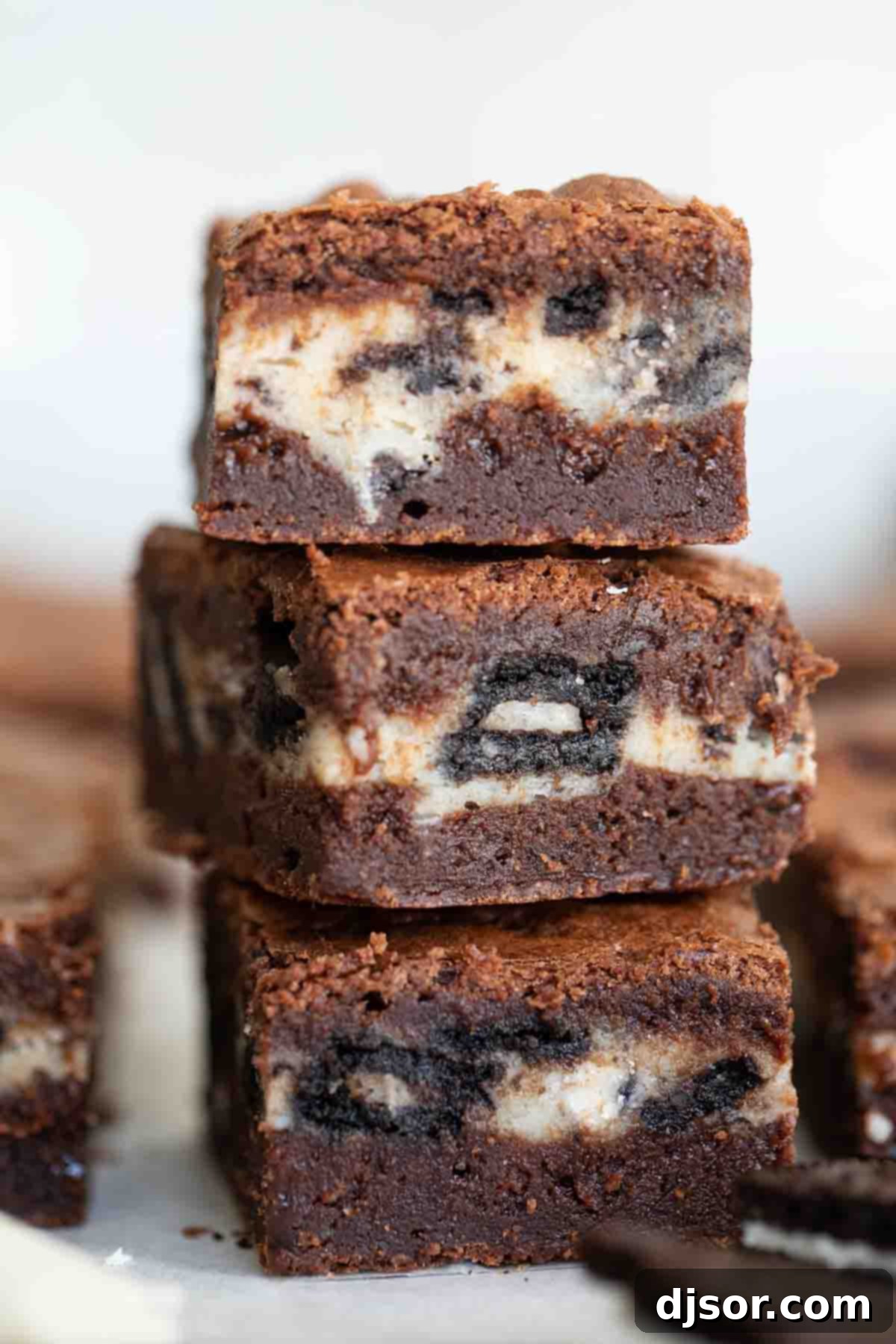 Three perfectly stacked Oreo brownies showcasing their fudgy texture and creamy filling