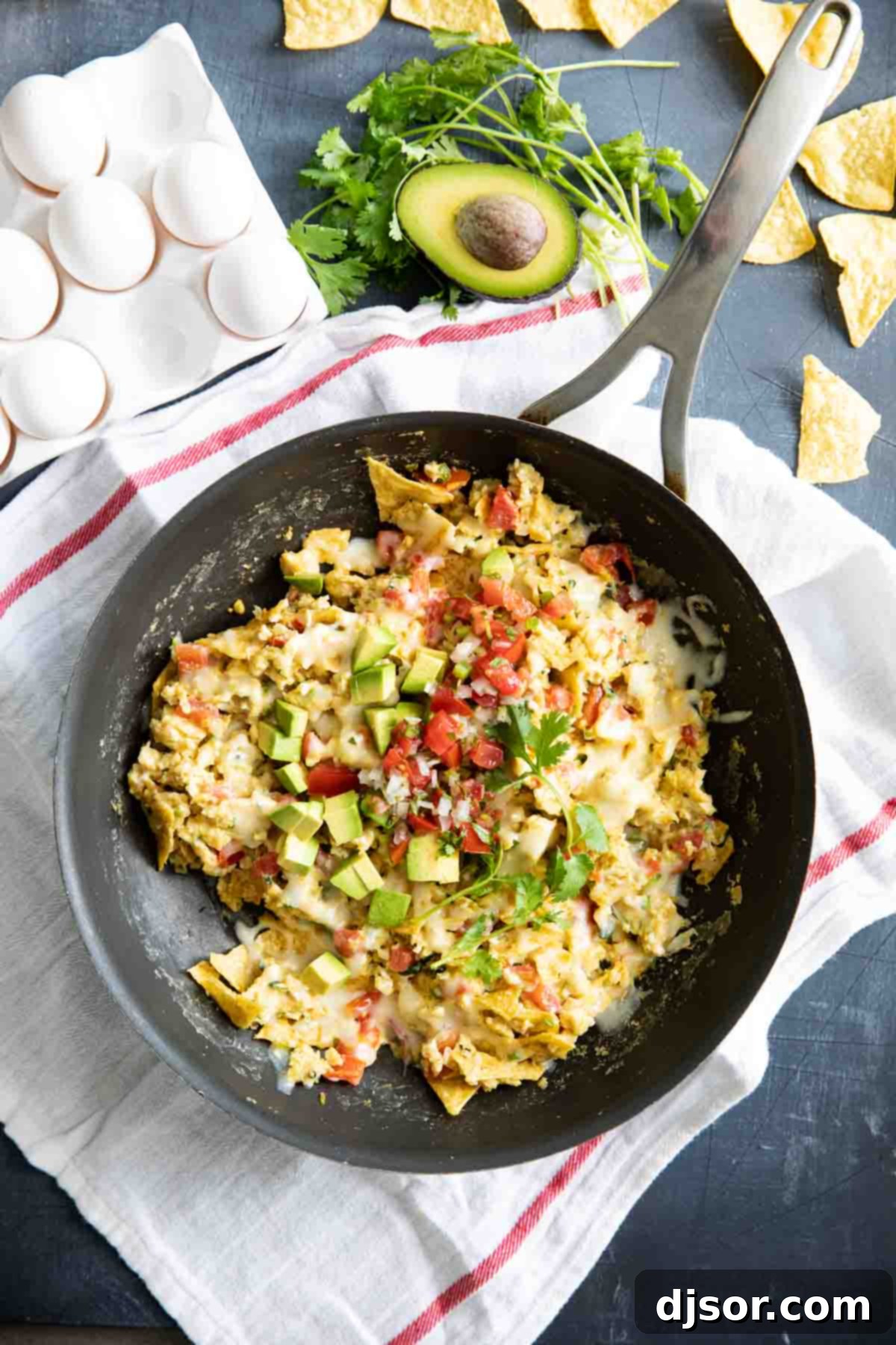 An overhead shot of freshly made Migas simmering in a large skillet, topped with melted cheese and ready for serving, highlighting its rustic appeal.