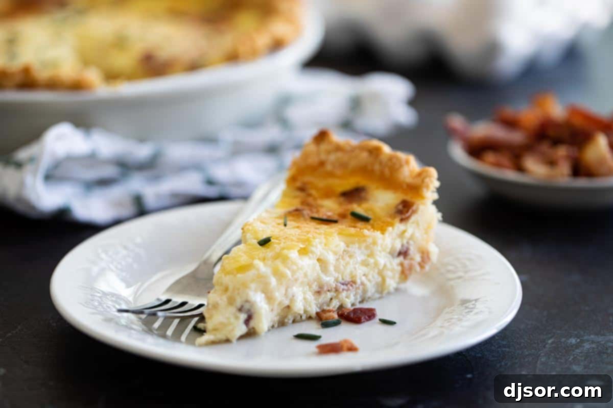 Classic Quiche Lorraine: The Ultimate Savory Pie with Bacon and Cheese A perfectly baked slice of Quiche Lorraine, garnished with fresh chives, resting on a white plate, ready to be enjoyed.