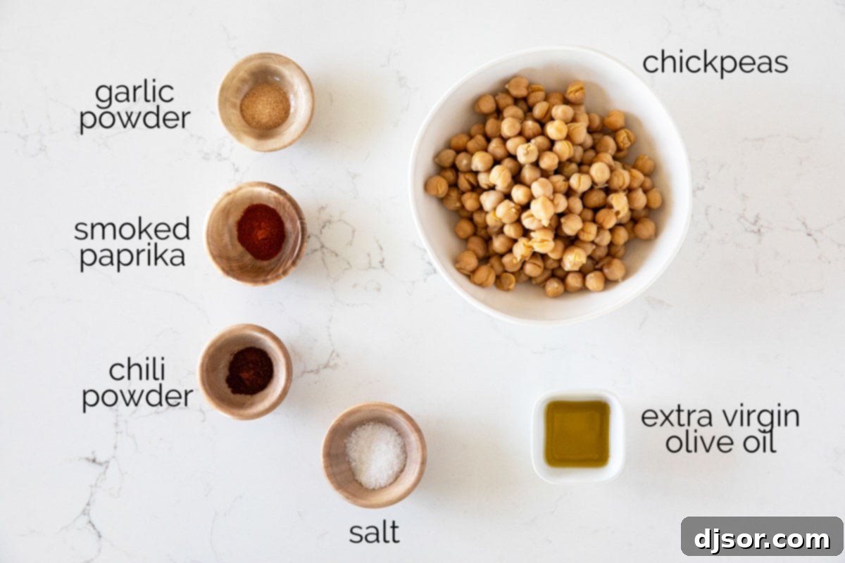 An assortment of simple ingredients including canned chickpeas, olive oil, and various spices arranged on a surface.