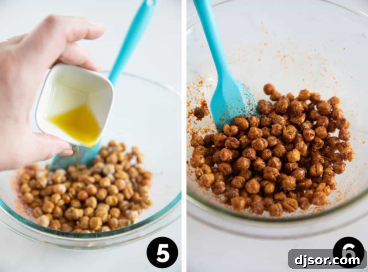 A large bowl of golden-brown roasted chickpeas being stirred with a wooden spoon, distributing a vibrant spice mixture.