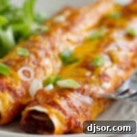 Cheesy Beef and Bean Enchiladas 4 Delicious Beef and Bean Enchiladas topped with a rich red homemade enchilada sauce and melted cheese, ready for serving.