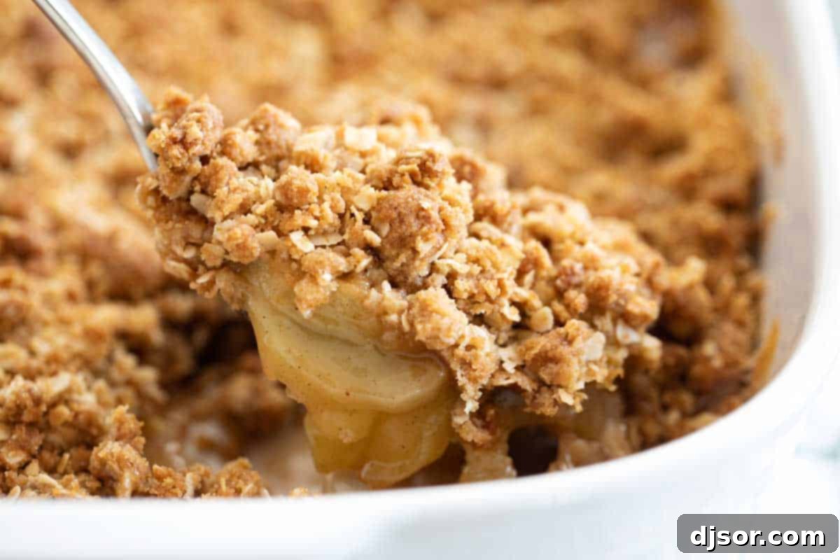 Delicious Spoonful of Apple Crisp A close-up shot of a spoonful of apple crisp, showcasing the juicy apples and crunchy oat topping.