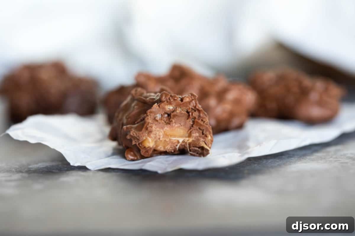 Caramel, chocolate, and crispy cereal make up these Homemade 100 Grand Candy Bars. These are so easy, you’ll want to keep all the ingredients on hand for when a craving hits! A perfectly portioned homemade 100 Grand candy bar with a bite taken out, showcasing the luscious caramel and crisp cereal interior beneath a glossy chocolate coating.