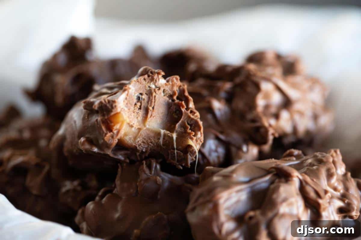 Caramel, chocolate, and crispy cereal make up these Homemade 100 Grand Candy Bars. These are so easy, you’ll want to keep all the ingredients on hand for when a craving hits! A delightful close-up of a bowl filled with homemade 100 Grand candy bars, with one on top showing a perfect bite, revealing its layered goodness.