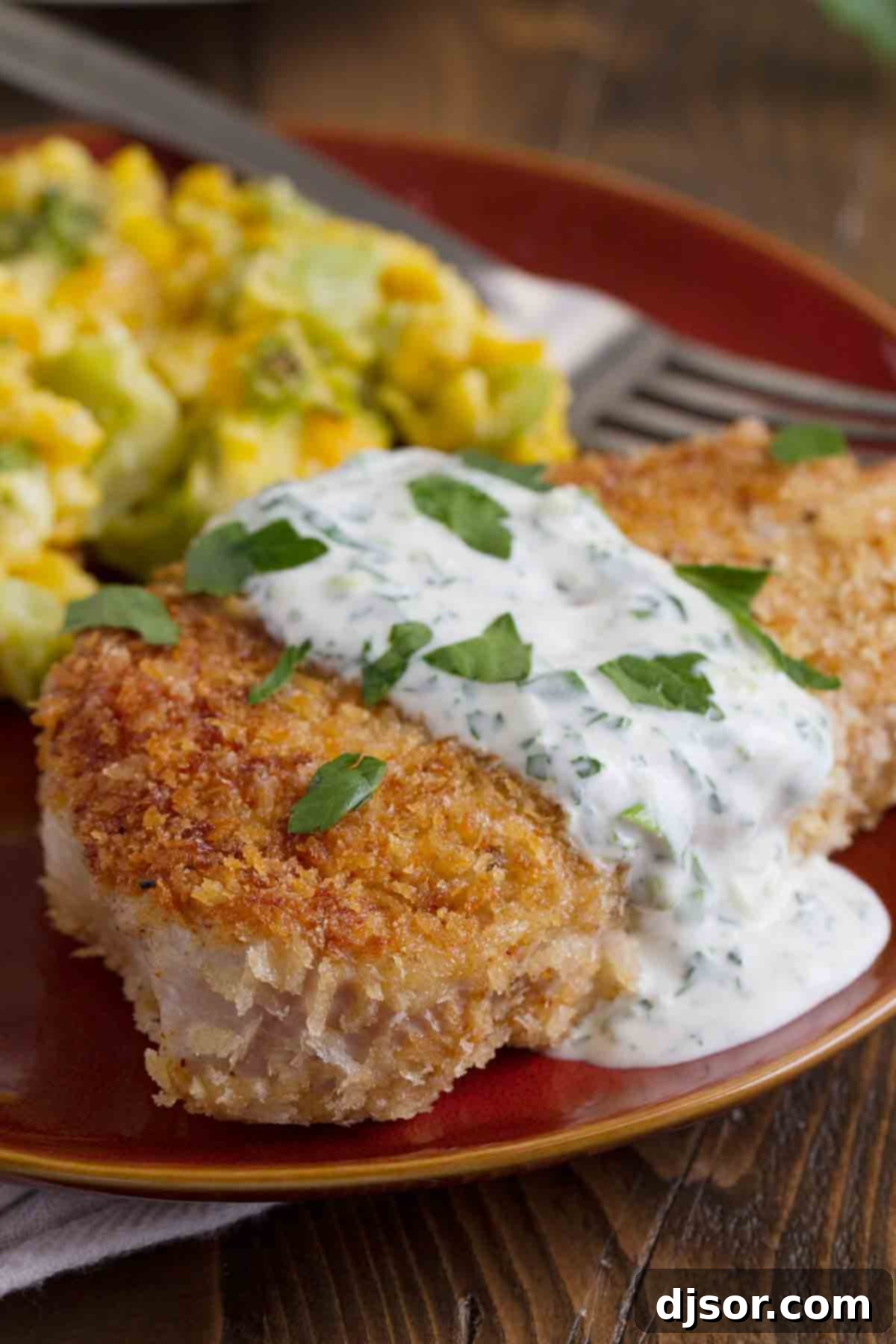 Panko Pork Chops with Creamy Herb Dressing: A Quick and Flavorful Dinner Crispy panko-crusted pork chops drizzled with creamy herb dressing, served fresh on a plate.