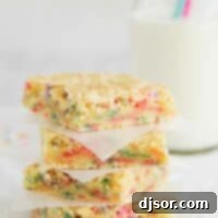 Four golden Cake Batter Blondies, generously adorned with colorful sprinkles and white chocolate chips, stacked neatly on a plate, promising a festive and easy-to-make dessert.