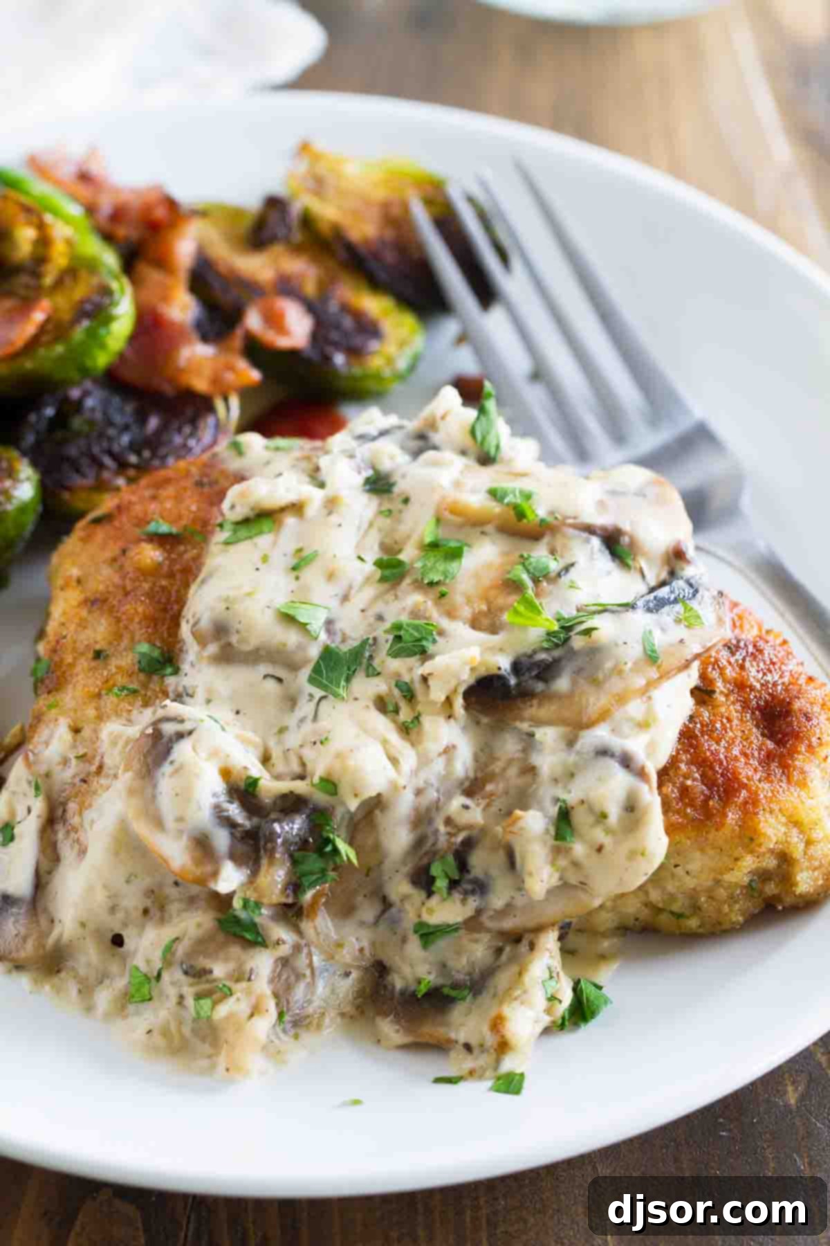 Delicious Italian Pork Chop with Mushroom Gravy pork chop on a plate with mushroom gravy