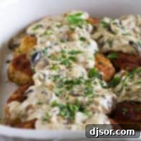 Tender Italian Pork Chops with Velvety Mushroom Sauce 2 Italian pork chops covered in a creamy mushroom gravy in a baking dish.