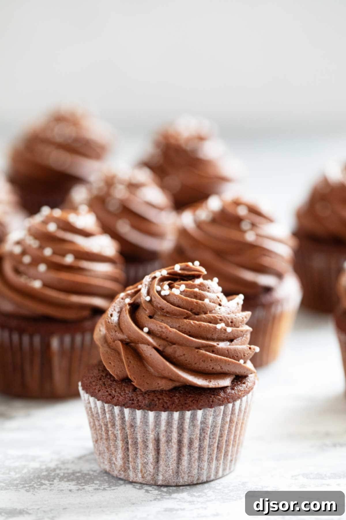 Eggless Chocolate Cupcakes topped generously with rich chocolate frosting.