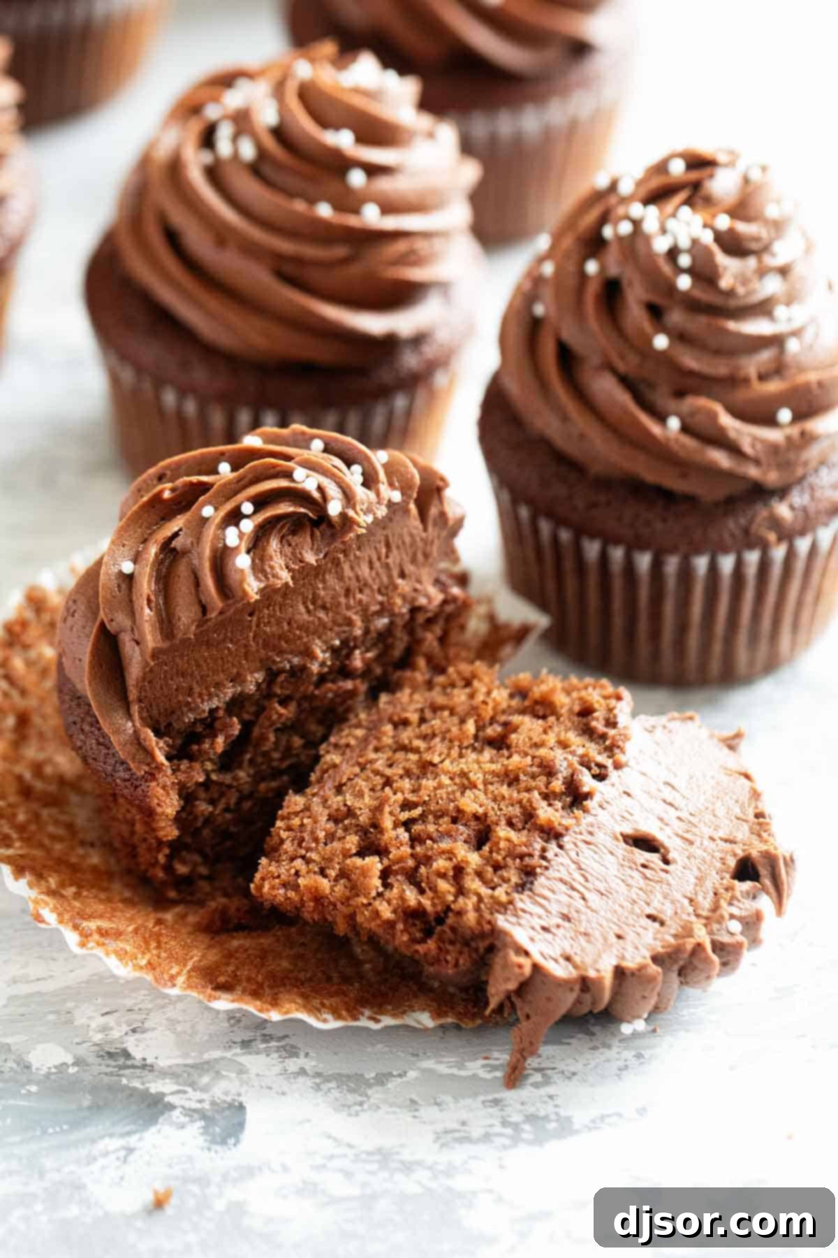 An Eggless Chocolate Cupcake cut in half to showcase its light and moist internal texture.