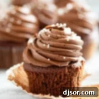 Eggless Chocolate Cupcakes with chocolate frosting with the wrapper pulled back.