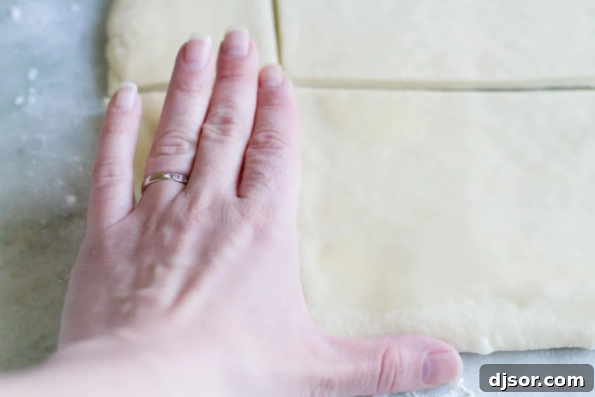 Slicing the Dough into Rectangles The buttered dough strips being carefully cut into uniform 2x4 inch rectangles, demonstrating the ideal size for individual Lion House Rolls.