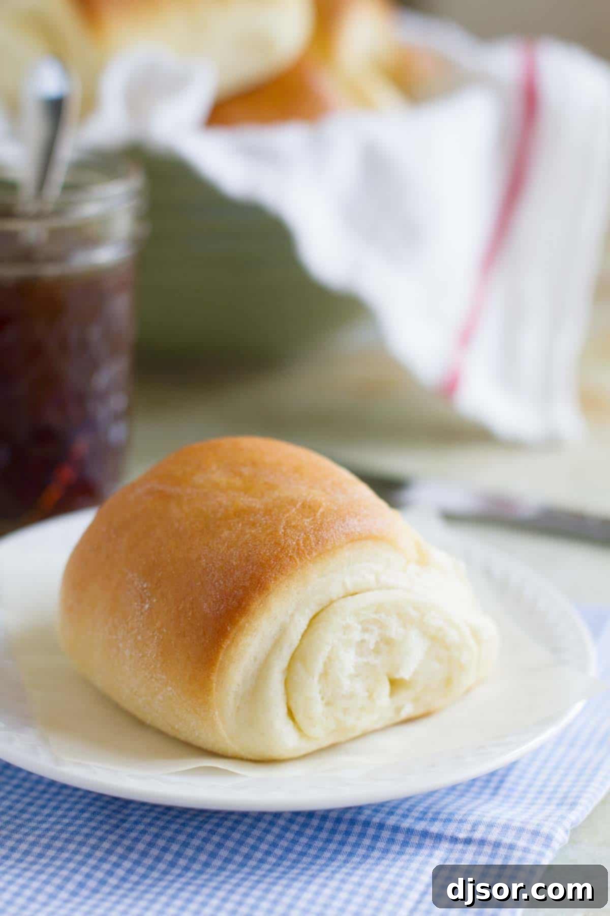 Baked Lion House Rolls piled on a white plate, ready to serve.