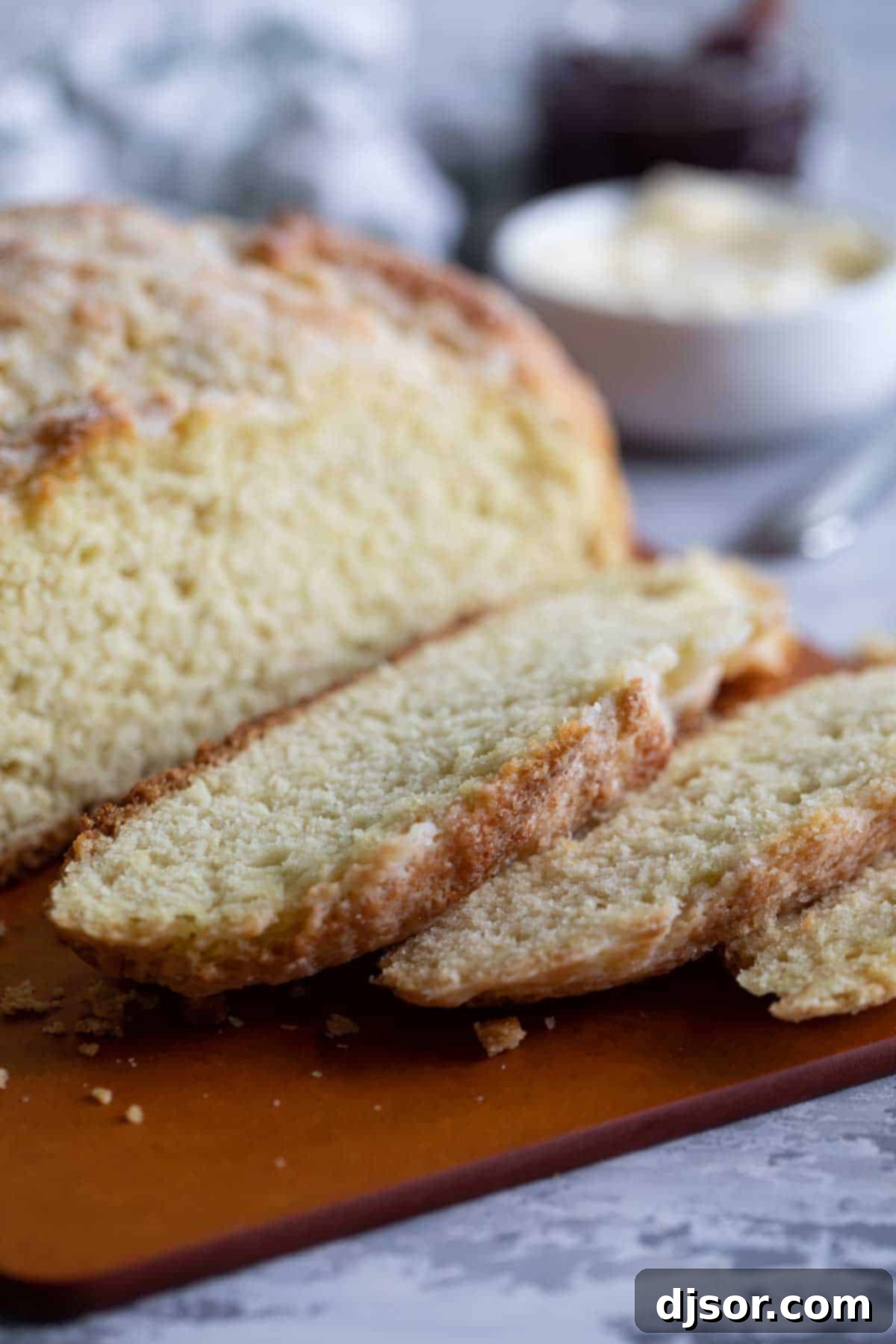 A freshly baked, golden-crusted Irish Soda Bread loaf, perfectly sliced to reveal its soft, fluffy interior.