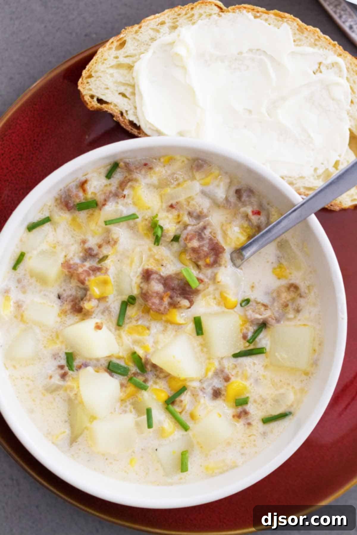 Easy Corn and Sausage Chowder - warm, comforting, filling and perfect for a cold day! This easy soup only takes a few ingredients and can be on the table in 40 minutes. Close-up shot of a single bowl of Easy Corn and Sausage Chowder, showing the texture of the corn, sausage, and potatoes.