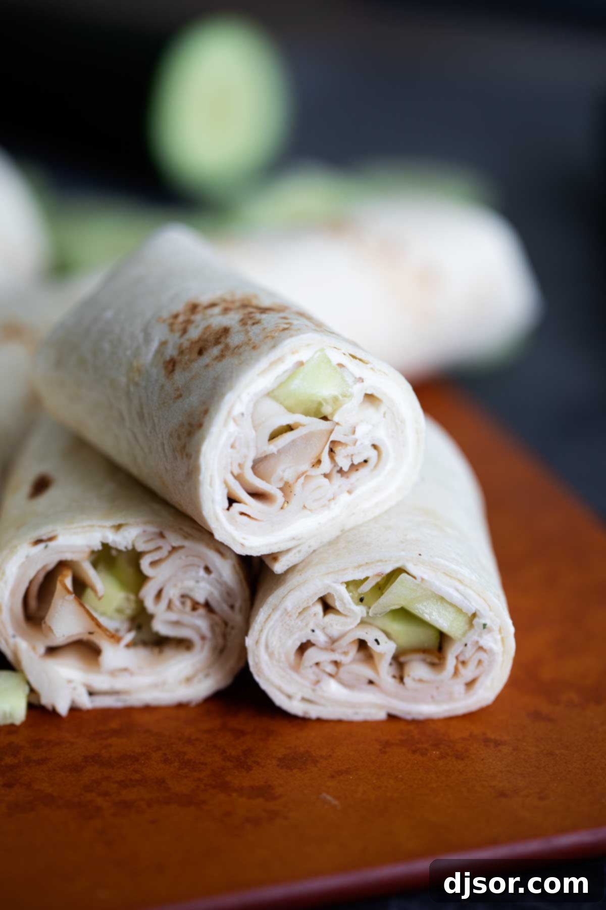 A Cucumber Ranch Turkey Wrap, neatly sliced in half and presented, highlighting its fresh ingredients and perfect spiral.