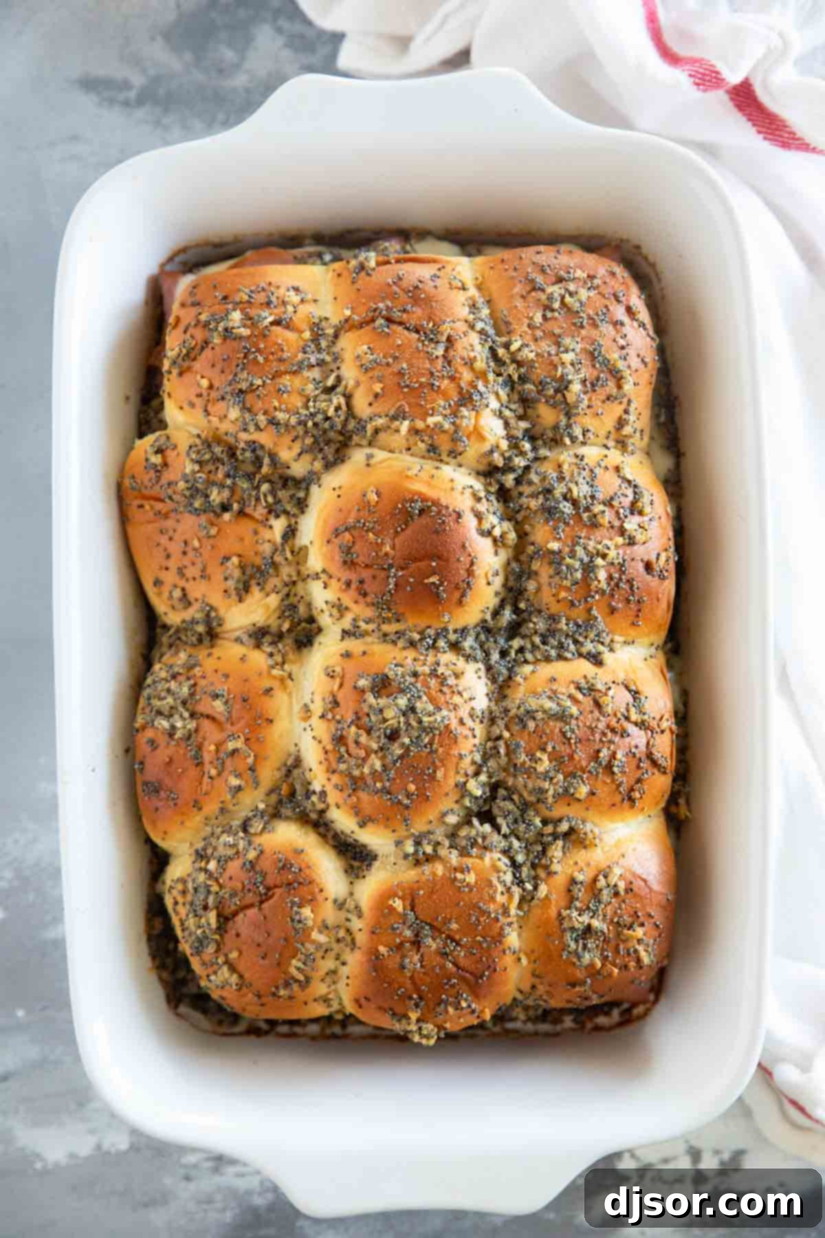 A top-down view of a baking dish filled with perfectly baked Ham and Cheese Sliders, golden brown and bubbly, fresh out of the oven.