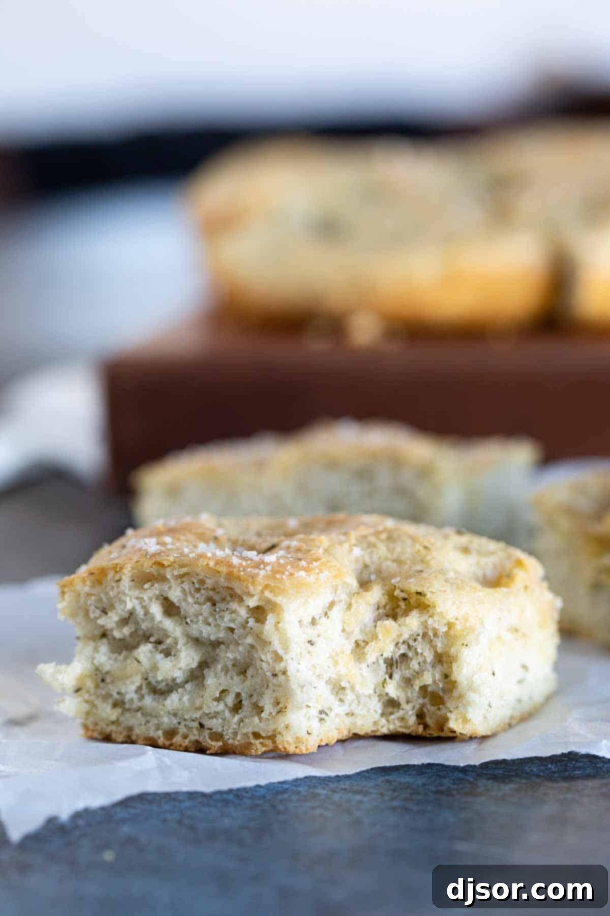 Enjoying a bite of freshly baked focaccia bread a tempting piece of focaccia bread with a bite taken from it, showcasing its airy texture