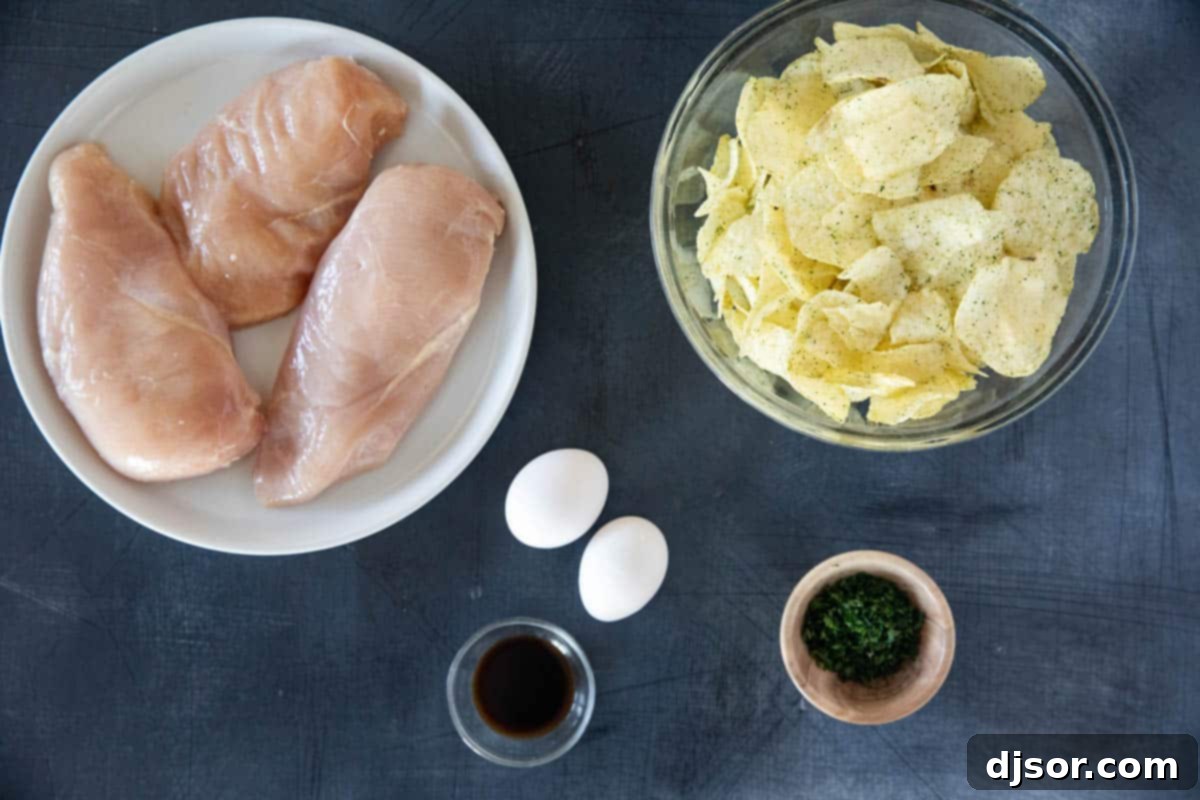 Ingredients for Potato Chip Chicken laid out on a kitchen counter: chicken breasts, potato chips, flour, parsley, eggs, Worcestershire sauce, and cooking oil.