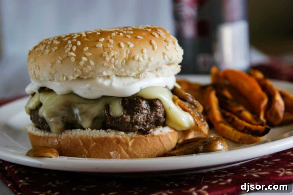 Gourmet Worcestershire Burgers with Gouda, Mushrooms, and Ranch Dressing A delicious Worcestershire Burger topped with melted Gouda, sautéed mushrooms, and creamy ranch dressing, ready to be enjoyed.