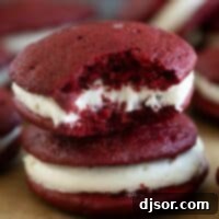 Two red velvet whoopie pies stacked on top of each other.