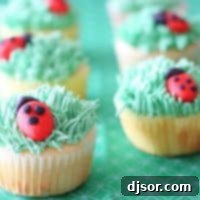 Delicious Ladybug Cupcakes with green buttercream grass and red marzipan ladybugs, perfect for spring or summer gatherings.