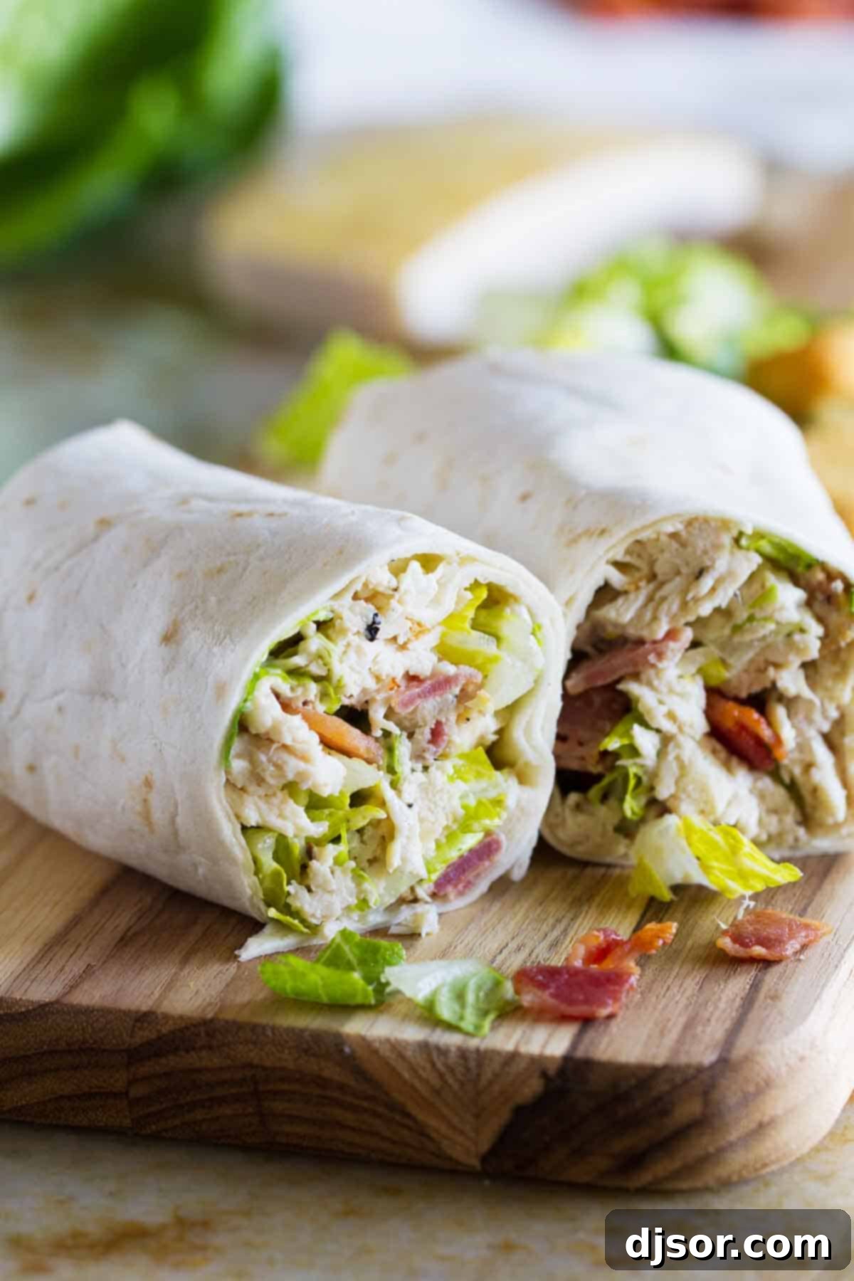 A delectable Chicken Caesar Wrap, expertly cut in half to reveal its flavorful filling of chicken, crisp romaine, and creamy Caesar dressing.