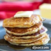 Rustic Cornmeal Pancakes 2 Cornmeal Pancakes stacked on a plate.