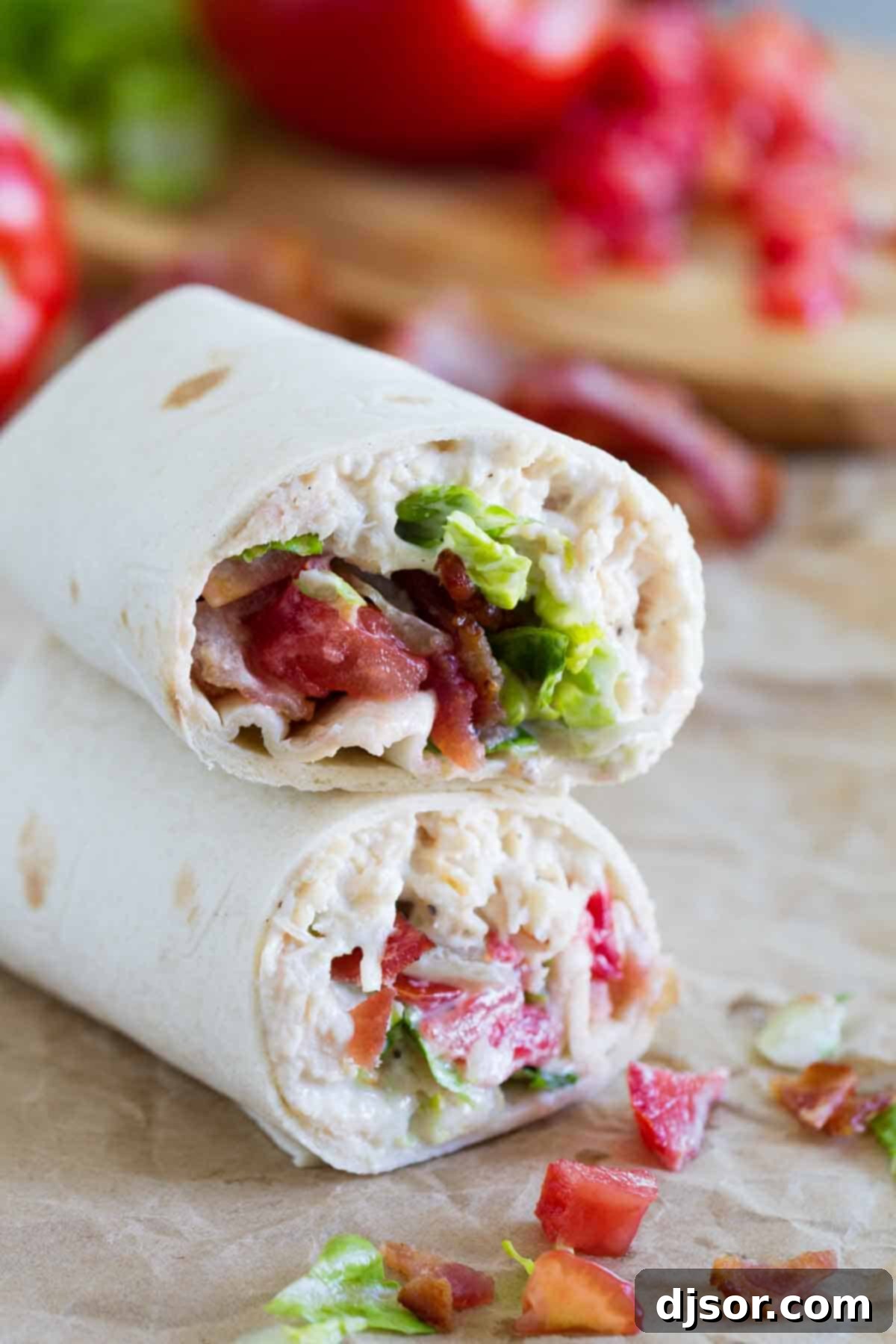 An easy lunch or picnic idea, these Chicken Bacon Ranch Wraps are made with only 6 ingredients, come together in a snap, and are always a family pleaser. Two halves of a delicious Chicken Bacon Ranch Wrap, perfectly stacked and ready to enjoy, showcasing the flavorful filling.