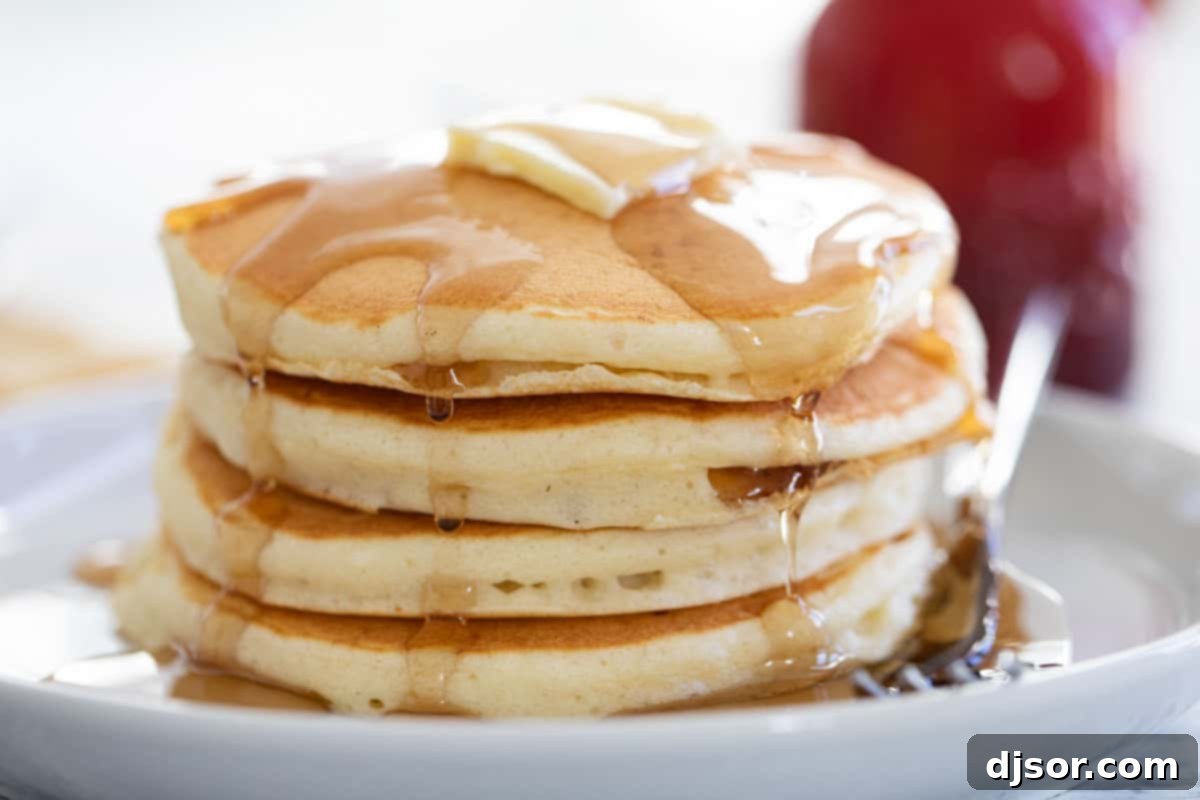 If you love fluffy and soft pancakes, this really is the Best Pancake Recipe! Made from pantry staples, these pancakes are the perfect breakfast recipe. stack of pancakes with syrup