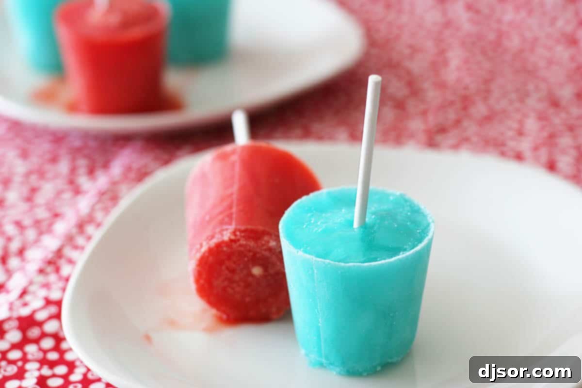 Homemade Ice Pops with Gelatin and Kool-Aid Two vibrant homemade ice pops on a plate, looking refreshing and colorful
