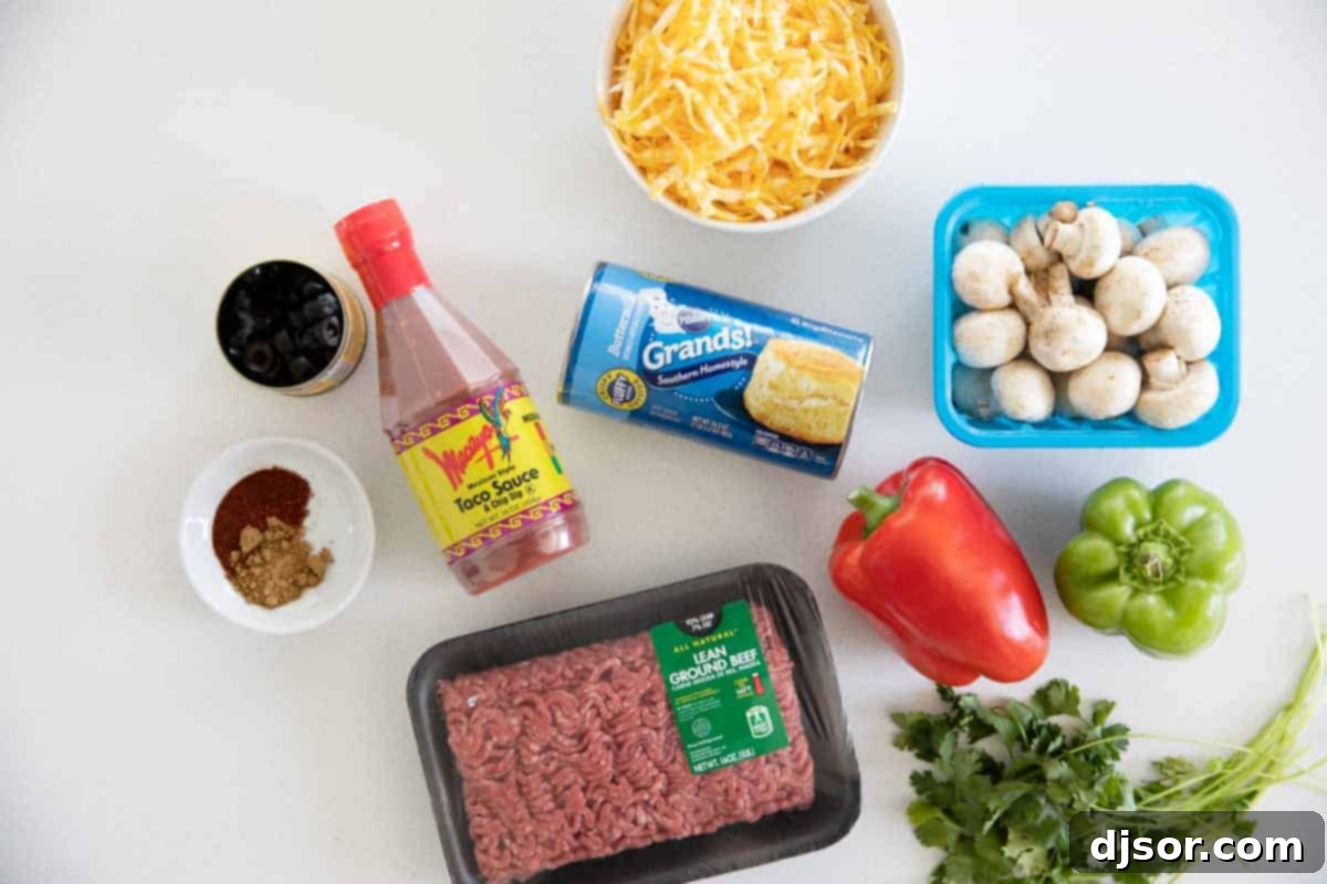 Essential ingredients for your next Taco Casserole: taco sauce, biscuits, cheese, olives, ground beef, bell peppers, mushrooms, and spices. Various ingredients laid out on a kitchen counter, ready for making taco casserole.