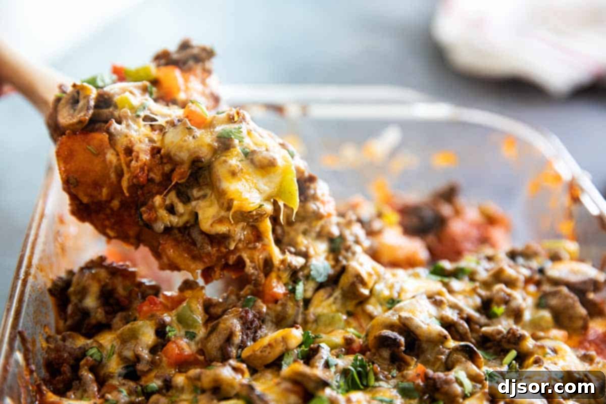 Serving up a generous portion of cheesy, savory Taco Casserole. A serving of taco casserole being dished out from the baking dish.