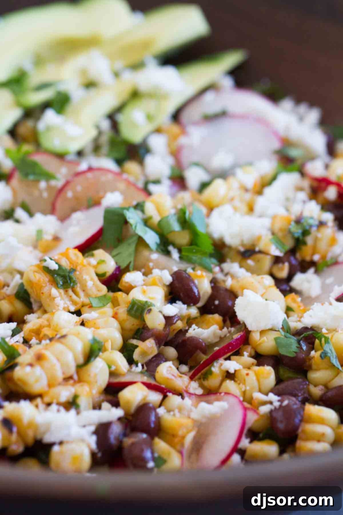A large bowl brimming with Grilled Corn and Black Bean Salad, ready to be served, featuring colorful ingredients.