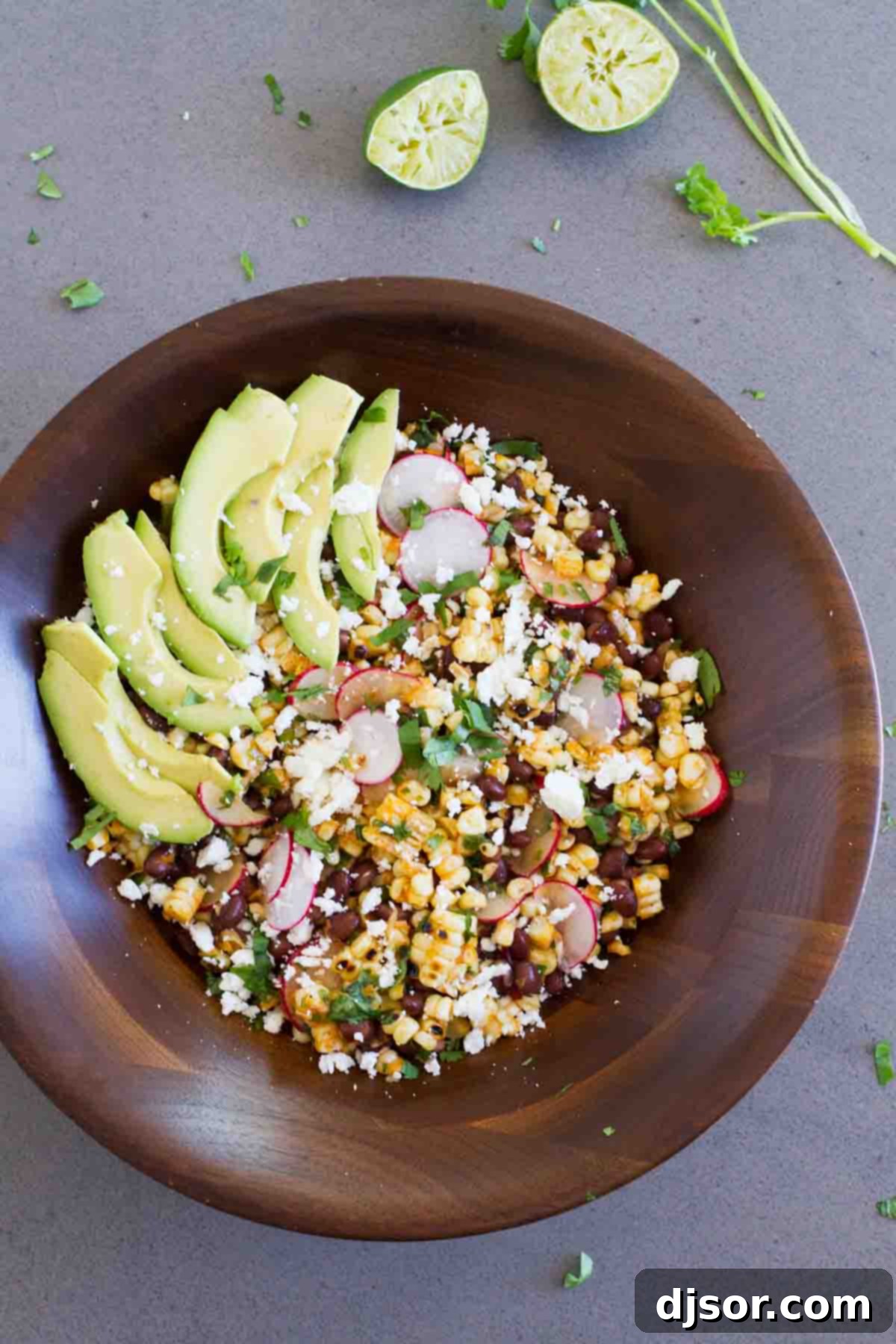 A beautiful wooden bowl filled with a vibrant Grilled Corn and Black Bean Salad, ready to be enjoyed outdoors.