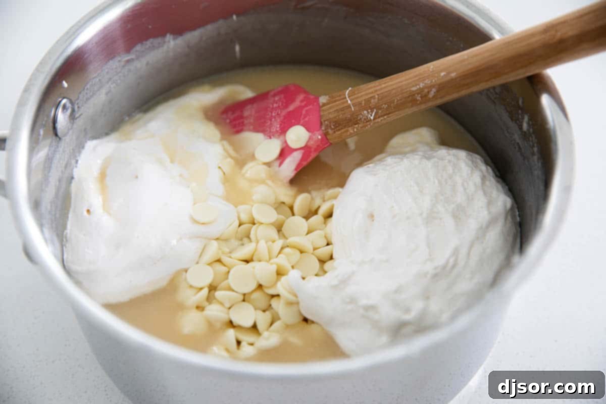 Preparing the creamy base for your 4th of July Tie-Dyed Fudge is the first step to creating this festive dessert. Close-up of ingredients being mixed for the patriotic White Chocolate Fudge, showing the creamy texture before coloring.