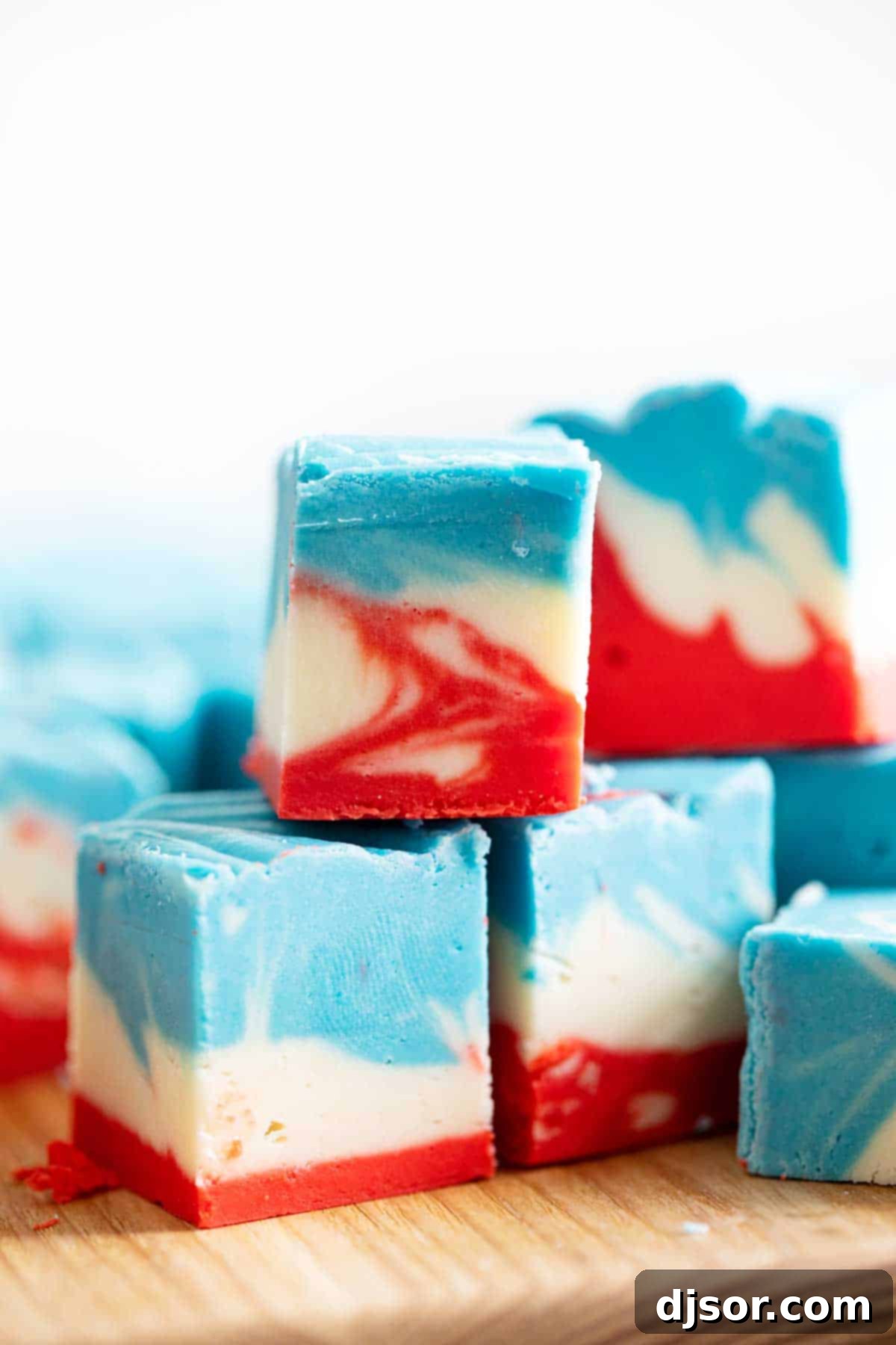 Indulge in the patriotic delight of this Red, White, and Blue White Chocolate Fudge, a creamy, tie-dyed treat for your celebration. A vibrant close-up of the Red, White, and Blue White Chocolate Fudge, showing the perfect tie-dye pattern and creamy texture.