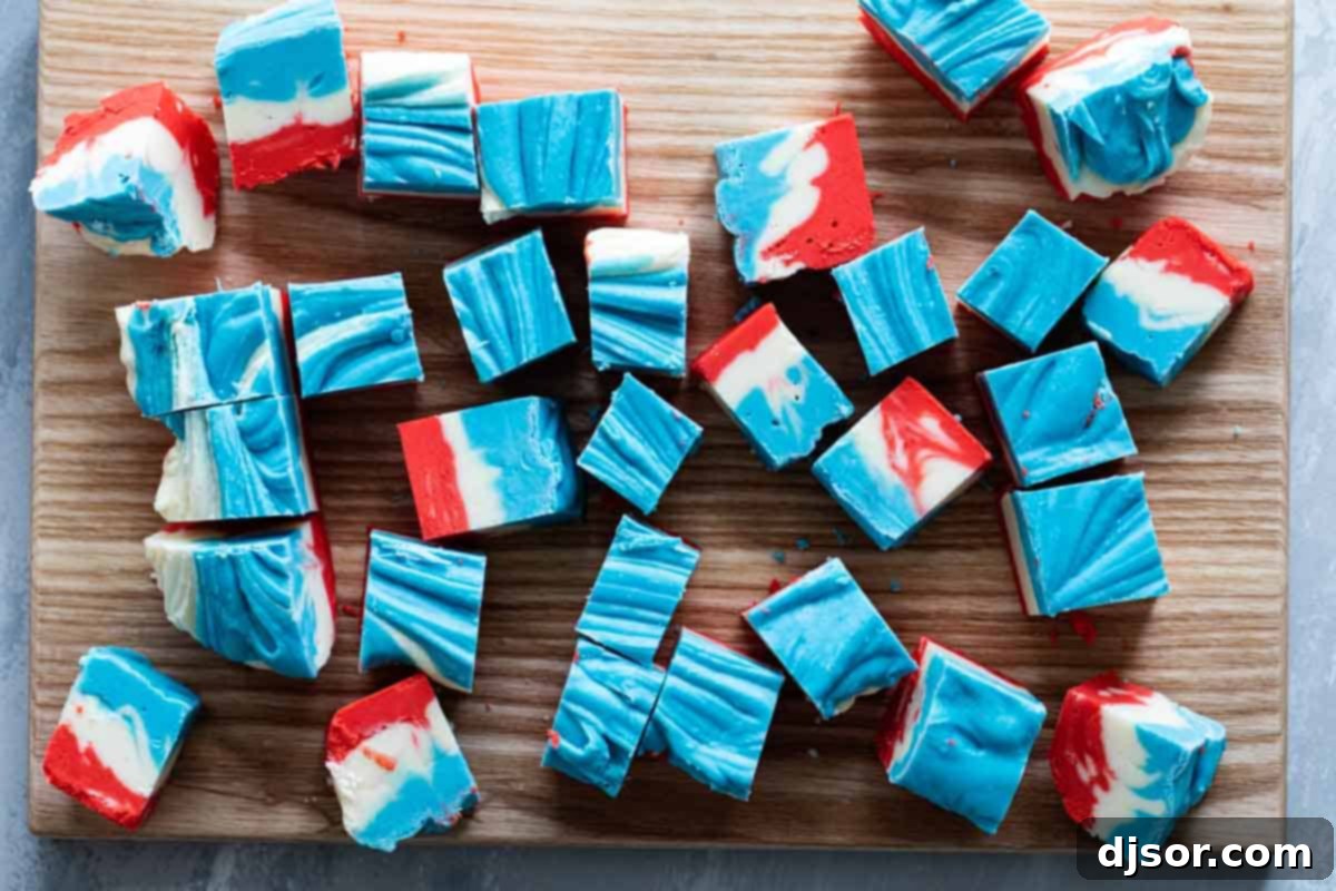 An artistic top view of the mesmerizing 4th of July White Chocolate Fudge, showcasing its unique tie-dye pattern. Overhead view of several pieces of 4th of July White Chocolate Fudge arranged on a serving platter, highlighting the tie-dye design.