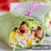 California Club Chicken Wrap with shredded chicken, avocado, mango, bacon, lettuce, and tomatoes.