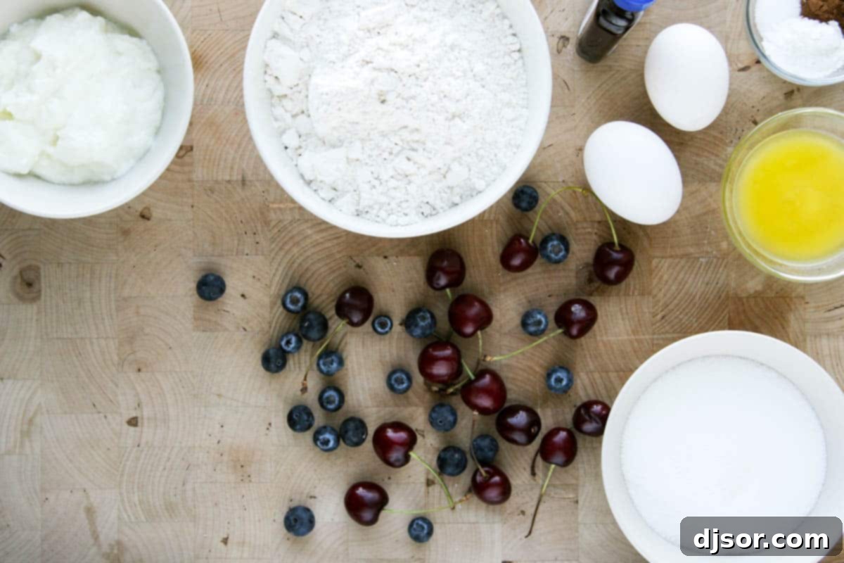 Baked Blueberry Cherry Doughnut Delights 3 Fresh ingredients laid out for blueberry cherry baked donuts, including flour, sugar, eggs, yogurt, blueberries, and halved cherries.
