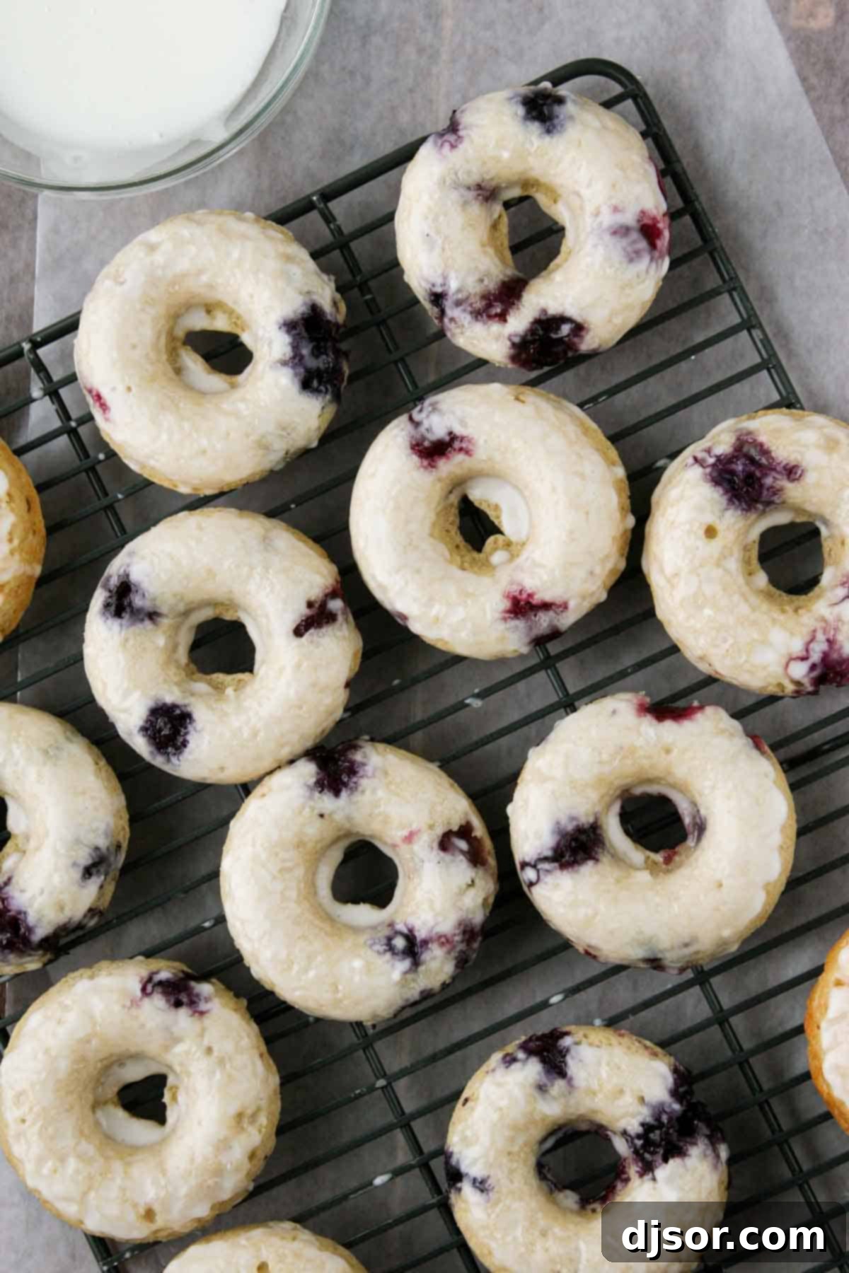 Baked Blueberry Cherry Doughnut Delights 4 Freshly baked blueberry cherry donuts cooling on a wire rack, glistening with a light glaze.
