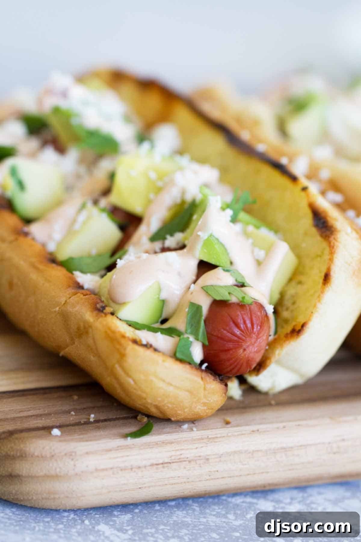 Hot dogs with Tex-Mex flair - this Mexican Hot Dog recipe gives you hot dogs topped with a chipotle mayonnaise, avocados, cheese and cilantro. A delicious Mexican Hot Dog, generously loaded with creamy chipotle mayonnaise, diced avocado, crumbled cotija cheese, and fresh cilantro.