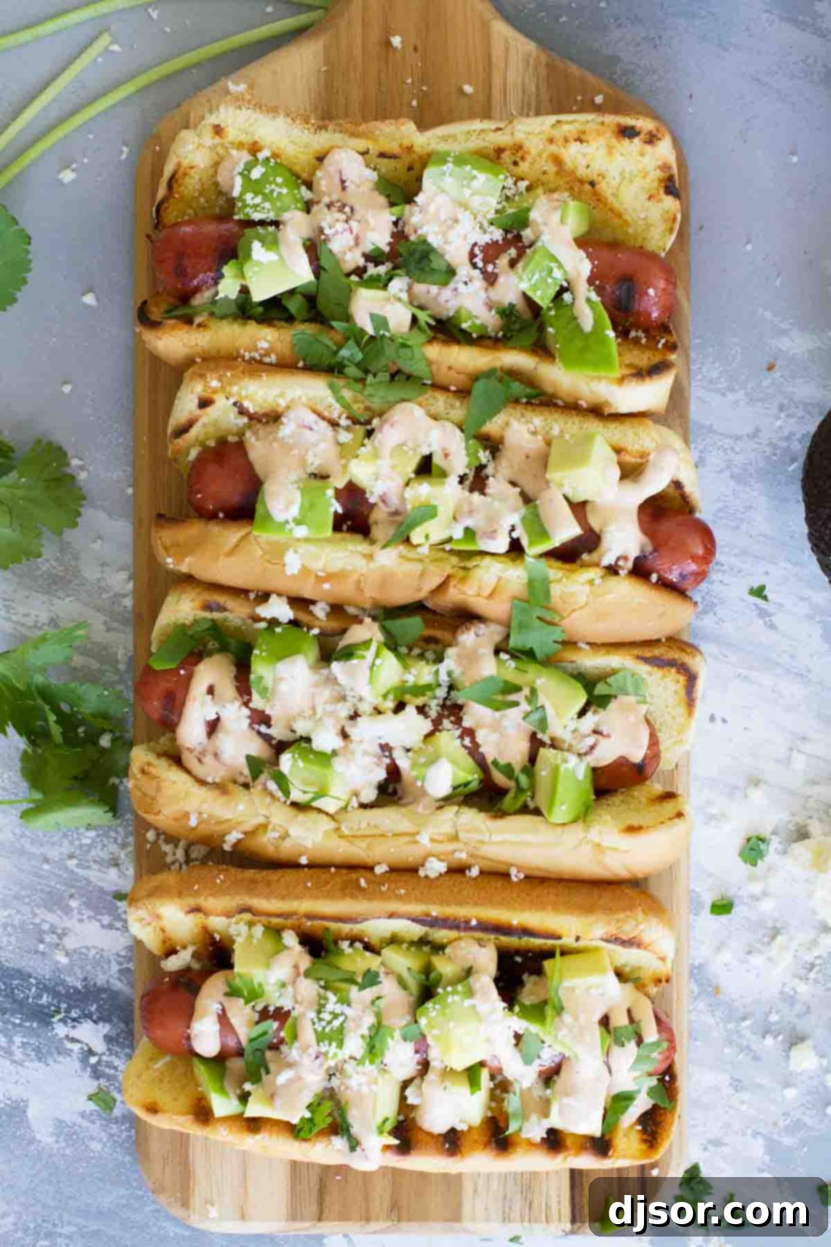 Hot dogs with Tex-Mex flair - this Mexican Hot Dog recipe gives you hot dogs topped with a chipotle mayonnaise, avocados, cheese and cilantro. Perfectly grilled hot dogs nestled in toasted buns, topped with a vibrant array of Mexican-inspired ingredients including chipotle mayo, avocado, cotija, and cilantro.