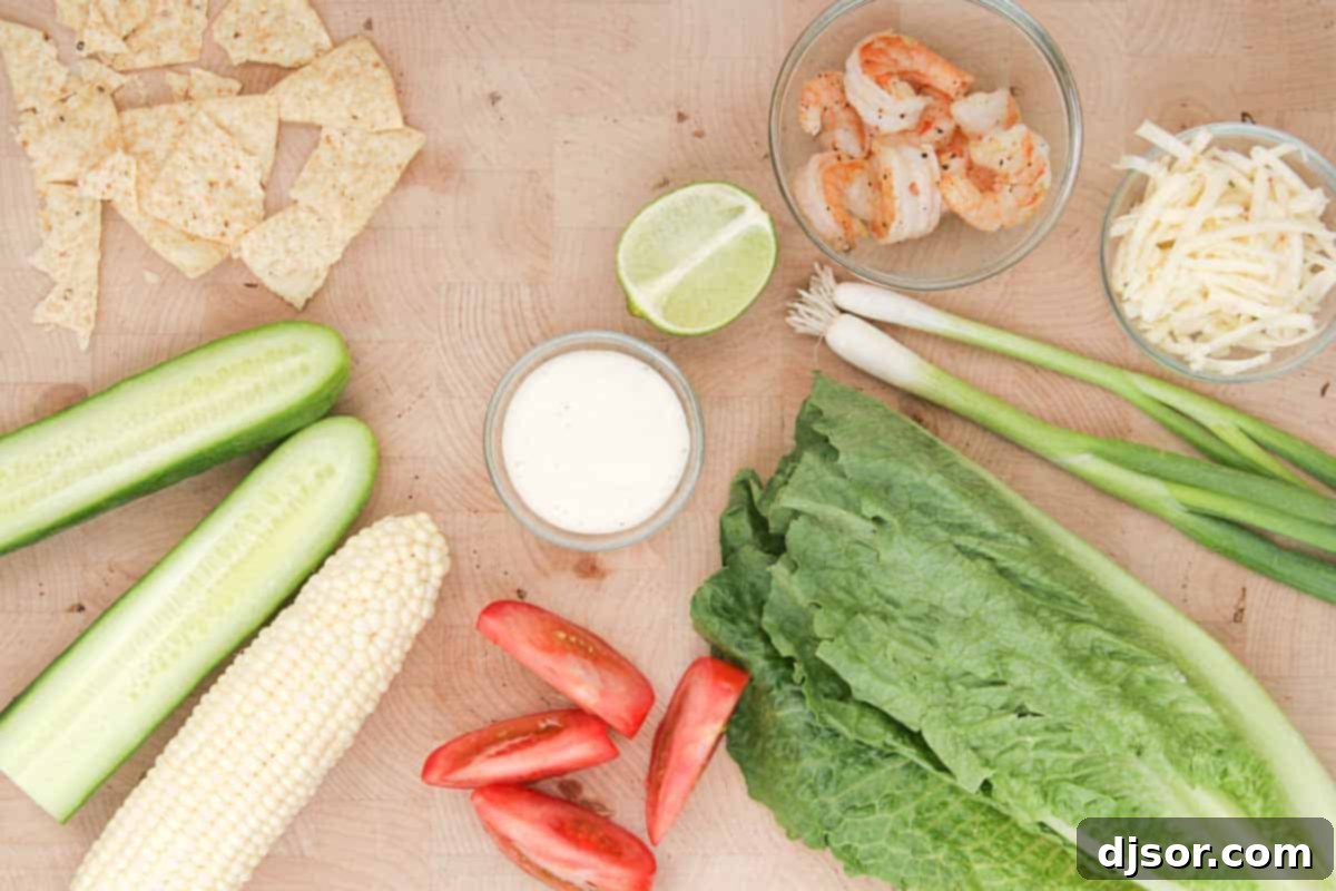 A selection of fresh ingredients including corn, shrimp, cucumber, and tomatoes laid out on a wooden surface, ready for preparing a shrimp and corn salad
