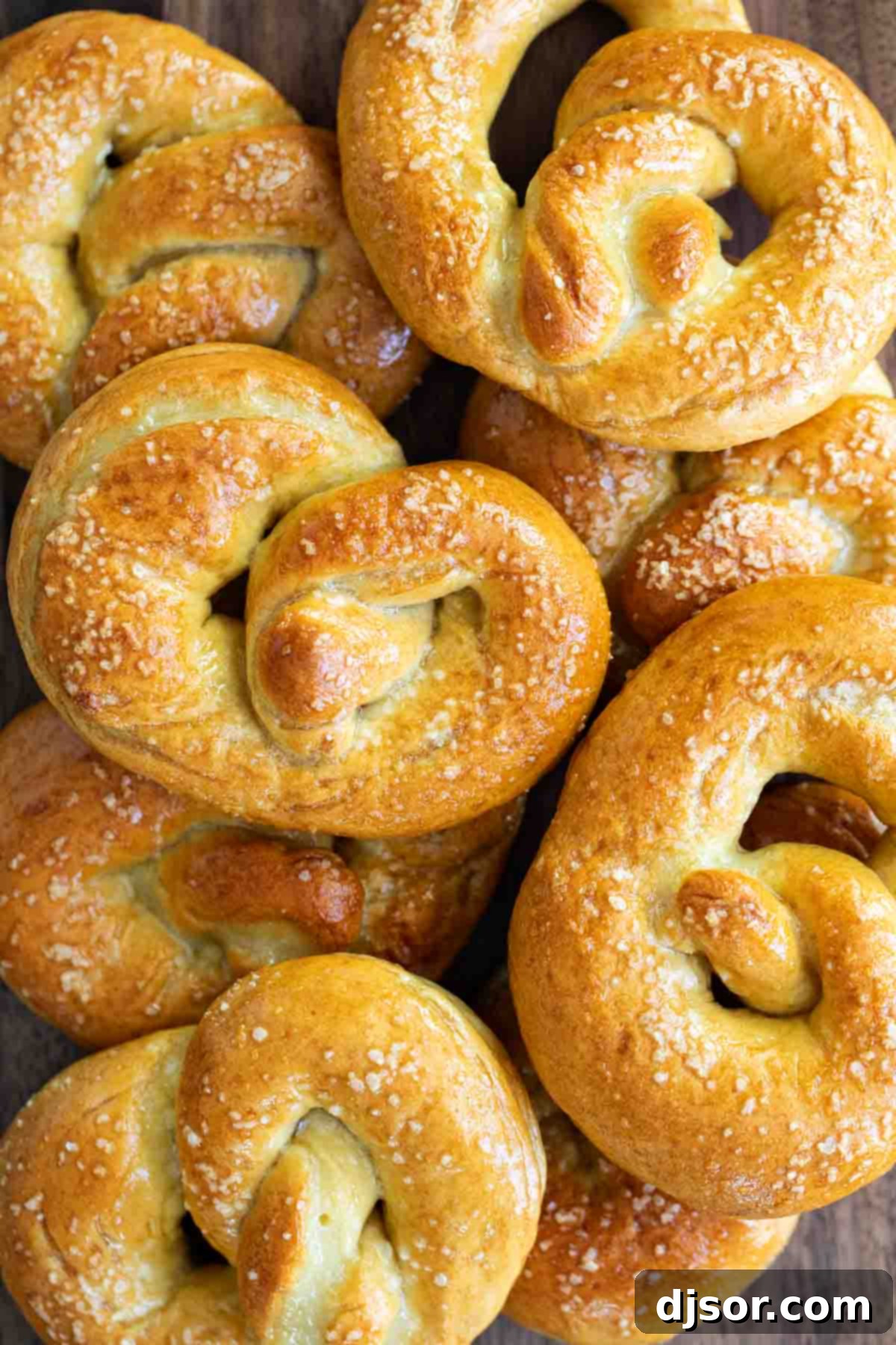 Overhead view of a stack of freshly baked soft pretzels, golden and shiny