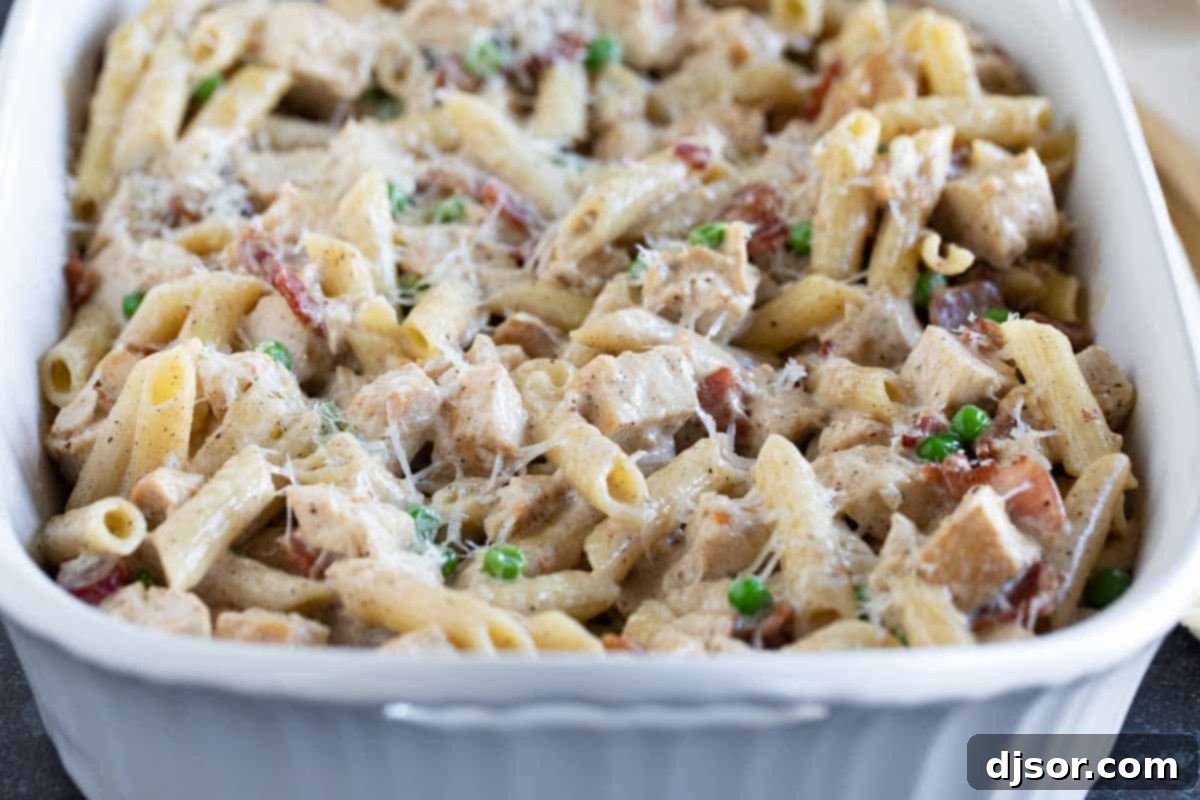 A golden-baked casserole dish brimming with creamy Chicken Bacon Pasta, perfectly heated and ready for serving. Full casserole dish with chicken bacon pasta.
