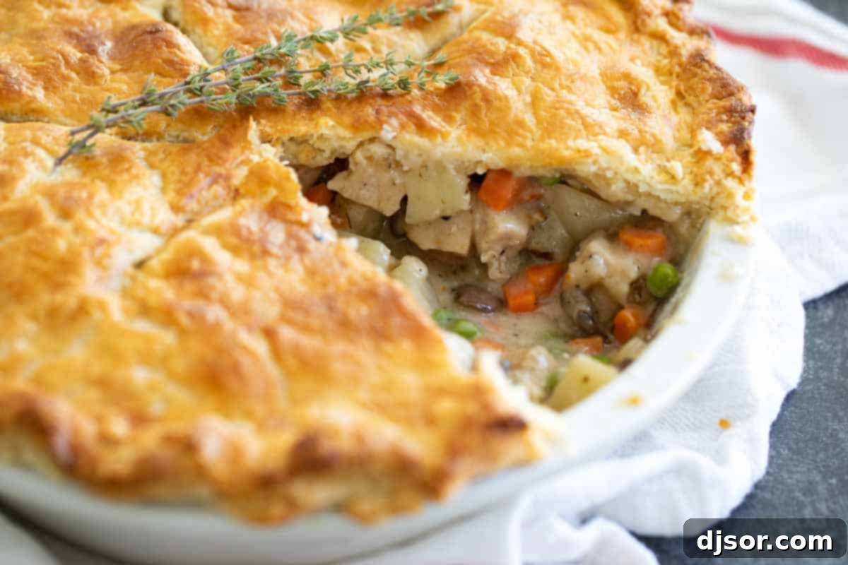 Golden Homemade Chicken Pot Pie, Sliced and Ready to Serve A delicious homemade chicken pot pie with a slice carefully removed, revealing the creamy, flavorful filling.