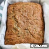 Garden Fresh Zucchini Loaf 2 Close-up of a perfectly baked zucchini bread loaf, showcasing its golden crust and delicious texture.