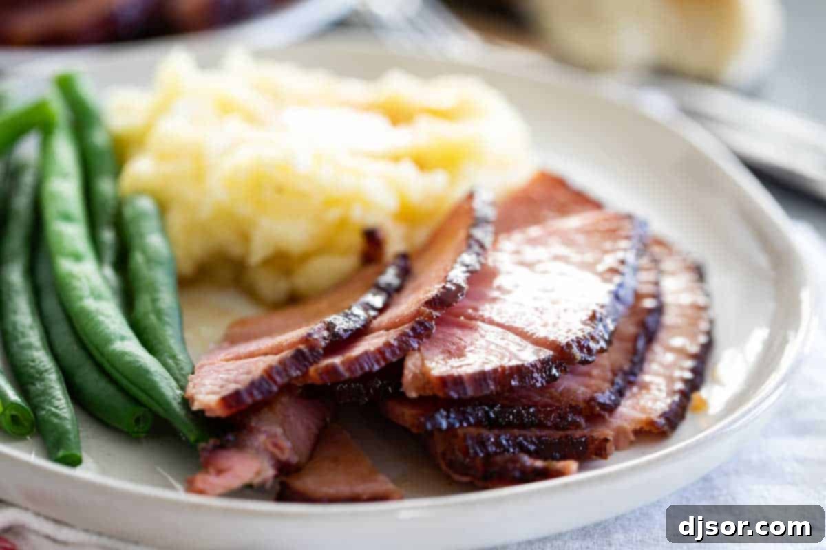 Glazed Ham Dinner Plate A festive plate featuring slices of glazed ham, roasted potatoes, and fresh green beans.